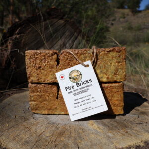 Two Original Paper Trail Fire Bricks bundled together on an outdoor tree stump