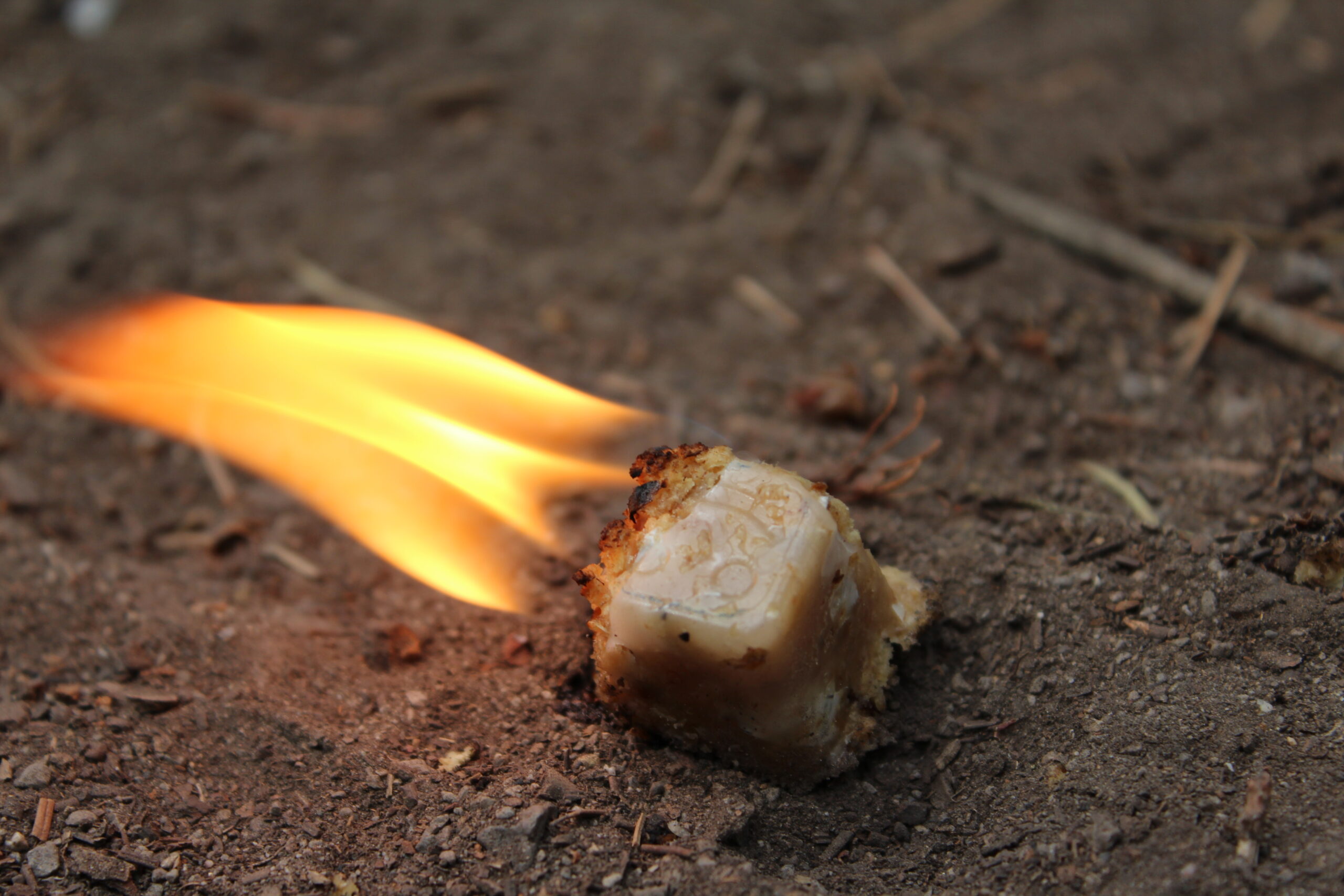 A single Smile Starter burning on bare ground outdoors